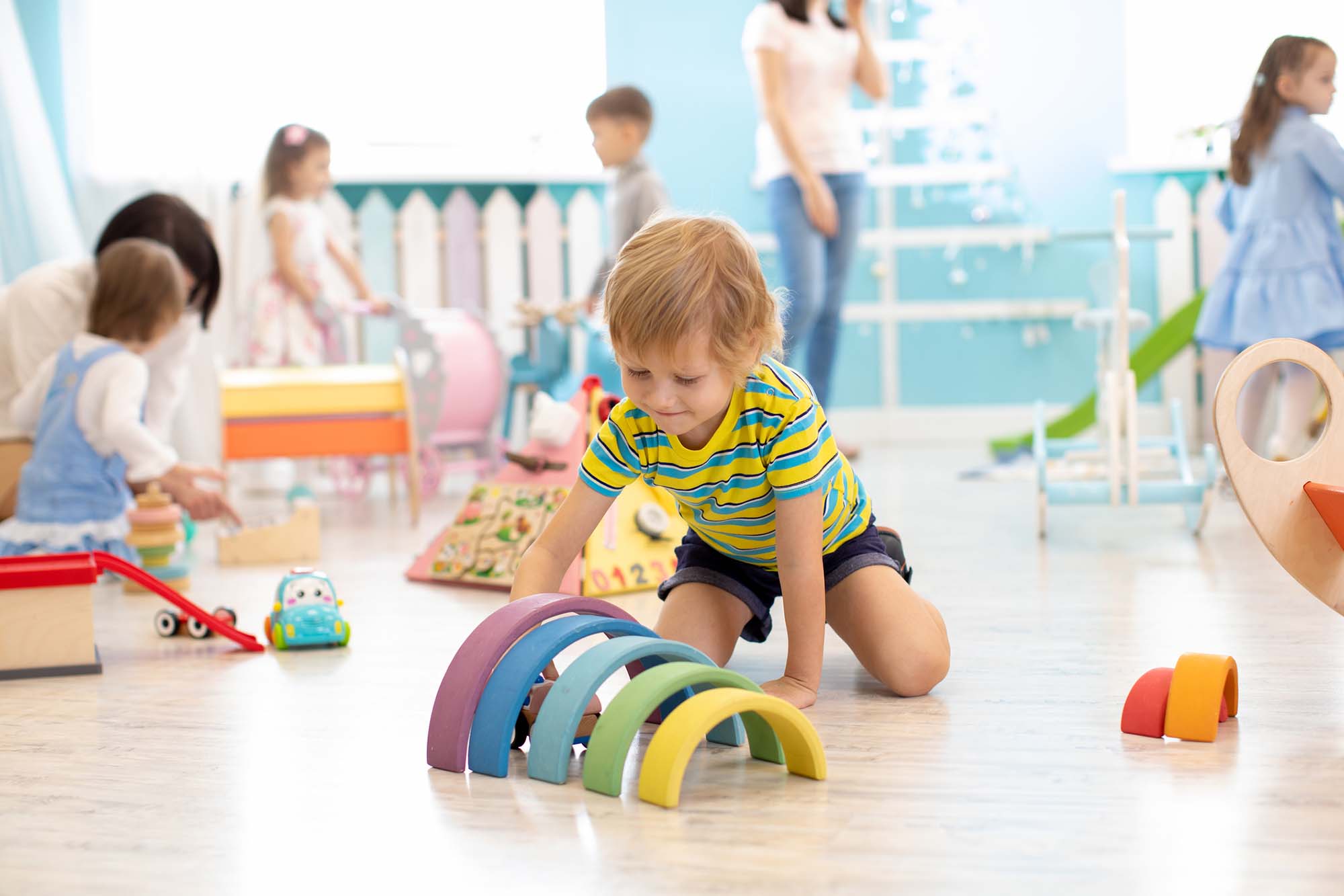 Kids playing on floor with educational toys. Toys for preschool and kindergarten. Children in nursery or daycare